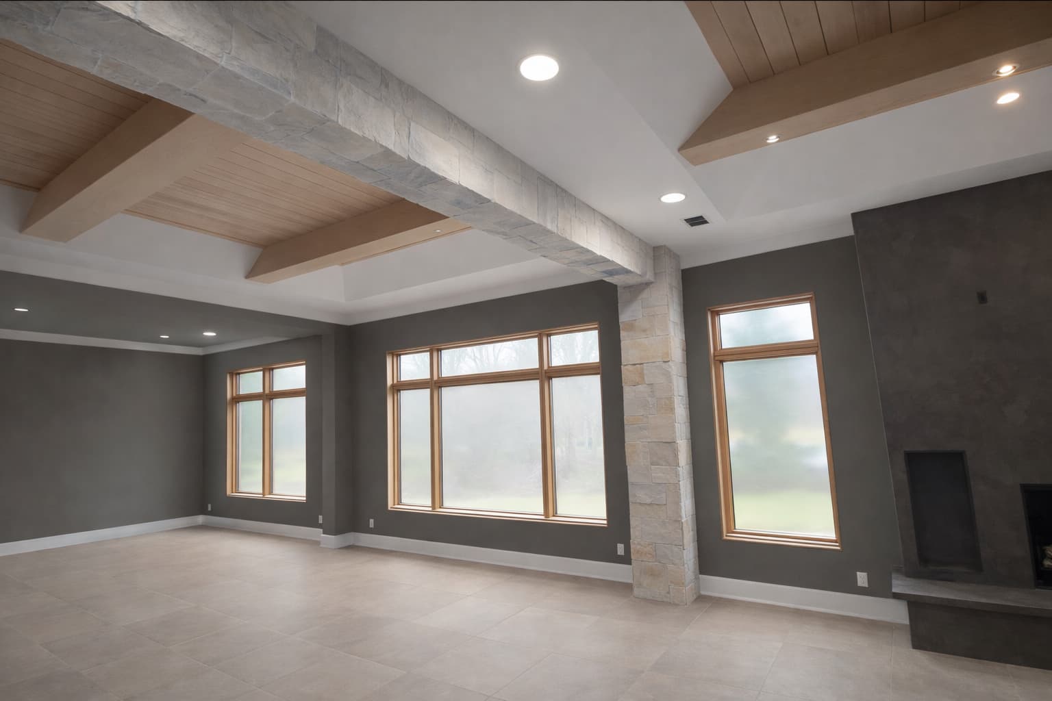 Interior great room with coffered ceiling, stone column, and plaster fireplace by Saugatuck Builders